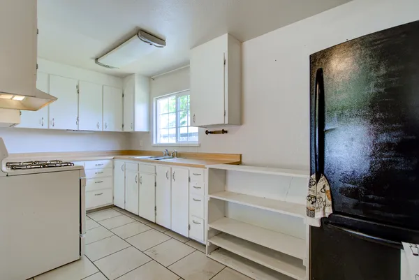 a kitchen with white cabinets and appliances