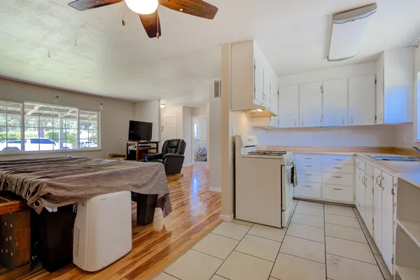 a kitchen with a sink a stove top oven a counter space and cabinets