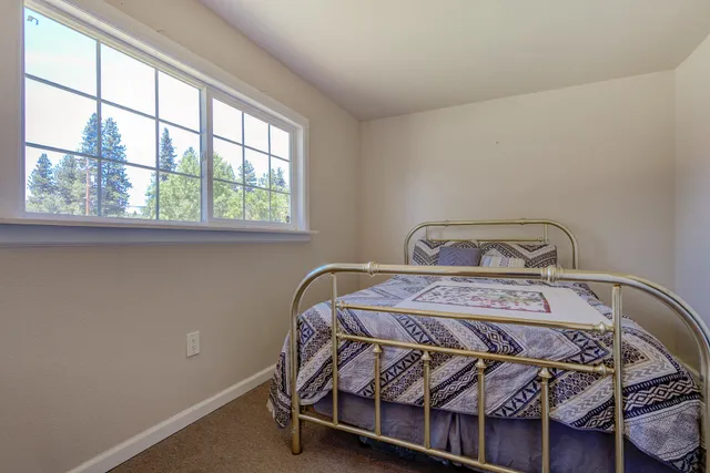 a bed sitting in a bedroom next to a window