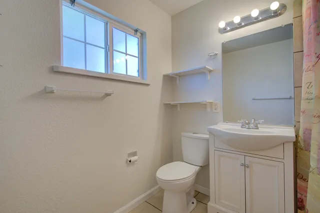 a bathroom with a toilet sink vanity and mirror