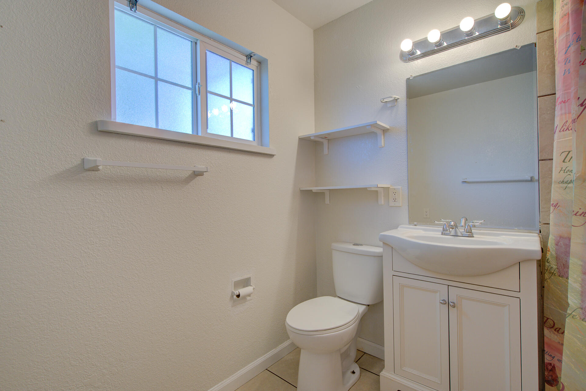 37153-55 Siskiyou Street Burney, CA 96013 - Photo 31 of 32 a bathroom with a toilet sink vanity and mirror