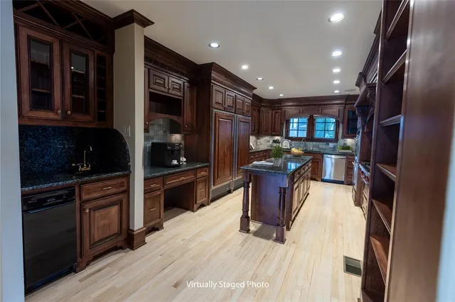 a kitchen with stainless steel appliances kitchen island granite countertop a refrigerator and a stove top oven