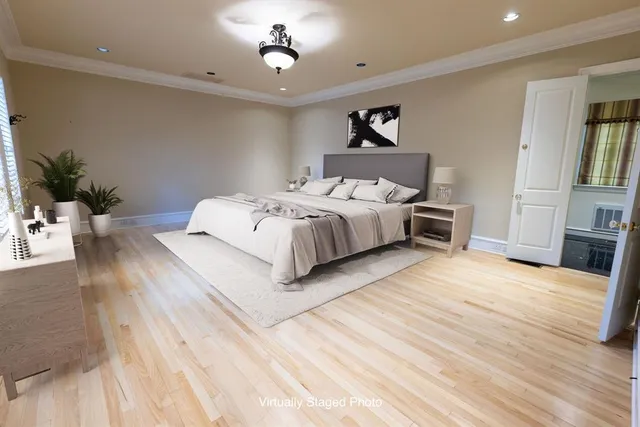 a spacious bedroom with a bed and a potted plant on the dresser