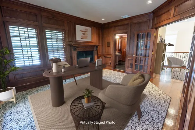 a living room with furniture a rug a fireplace and a large window