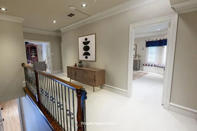 a view of a hallway with wooden floor and a bathroom