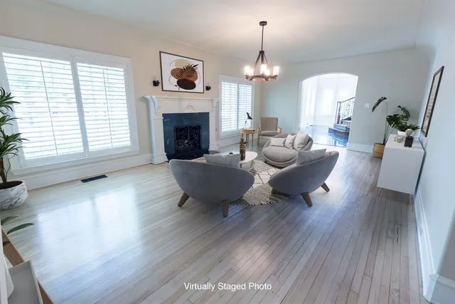 a living room with furniture a fireplace and a chandelier