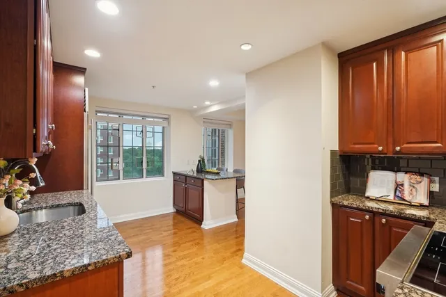 a view of a kitchen with kitchen island granite countertop stainless steel appliances stove sink and tub