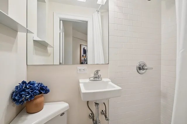 a bathroom with a sink a toilet and mirror