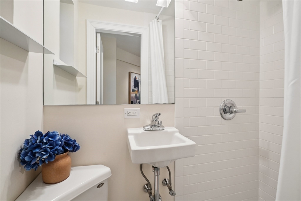 20 Chapel Street, Unit B811 Brookline, MA 02446 - Photo 16 of 32 a bathroom with a sink a toilet and mirror