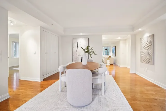 a living room with furniture potted plant and kitchen view