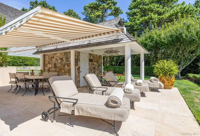 a view of a patio with couches table and chairs and potted plants