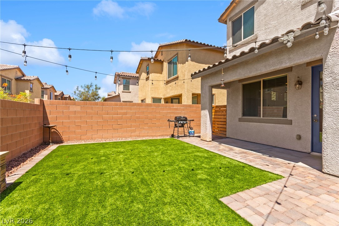 6435 Point Isabel Way Las Vegas, NV 89122 - Photo 46 of 57 A private backyard oasis features artificial turf and a covered patio area, perfect for relaxed outdoor enjoyment.