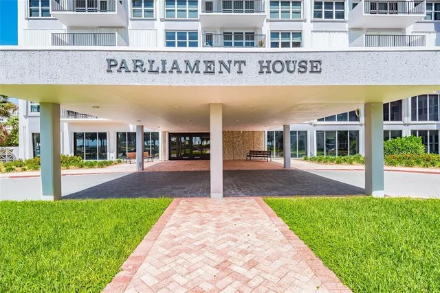 a view of a building with a yard and plants