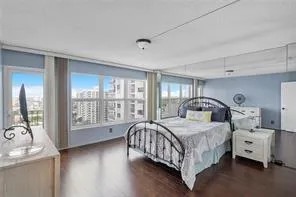 a bedroom with a bed and large windows