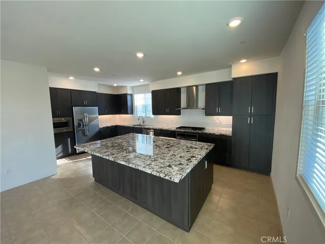 a large kitchen with kitchen island a large counter top and a sink