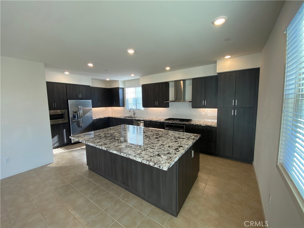 179 Cadence Irvine, CA 92618 - Photo 13 of 41 a large kitchen with kitchen island a sink stove and a refrigerator