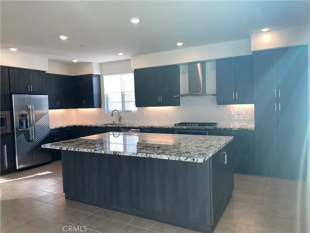 a kitchen with stainless steel appliances granite countertop a sink a stove a refrigerator and a oven