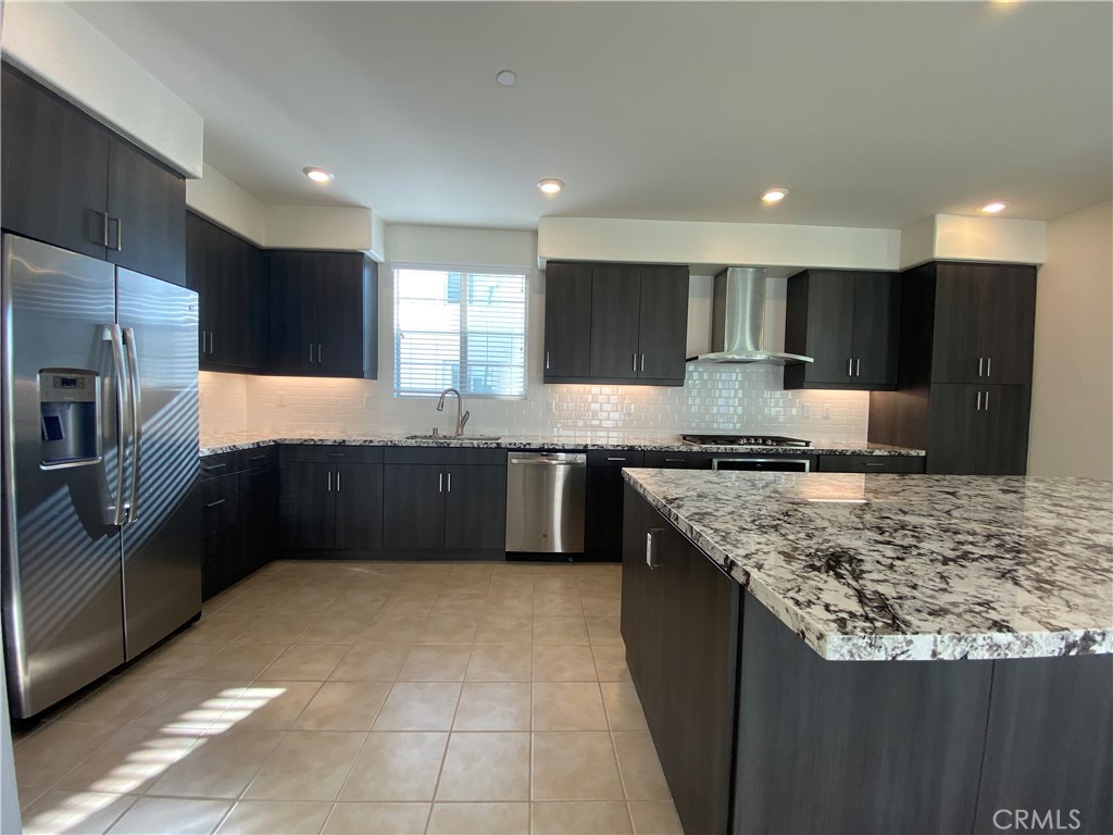 179 Cadence Irvine, CA 92618 - Photo 15 of 41 a kitchen with stainless steel appliances granite countertop a sink a stove a refrigerator and a oven