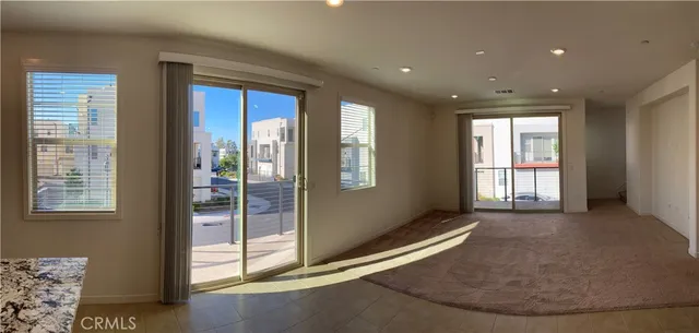 an empty room with windows and chandelier