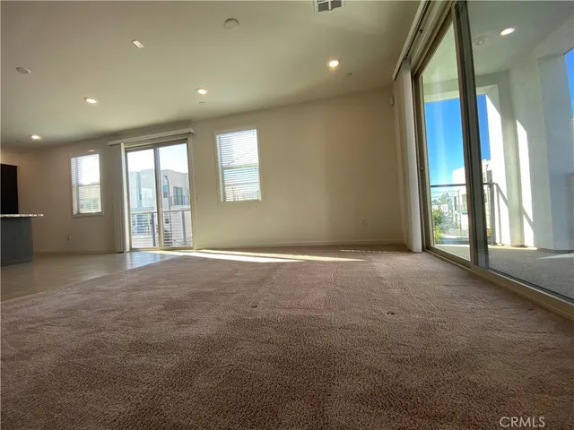 an empty room with windows and chandelier
