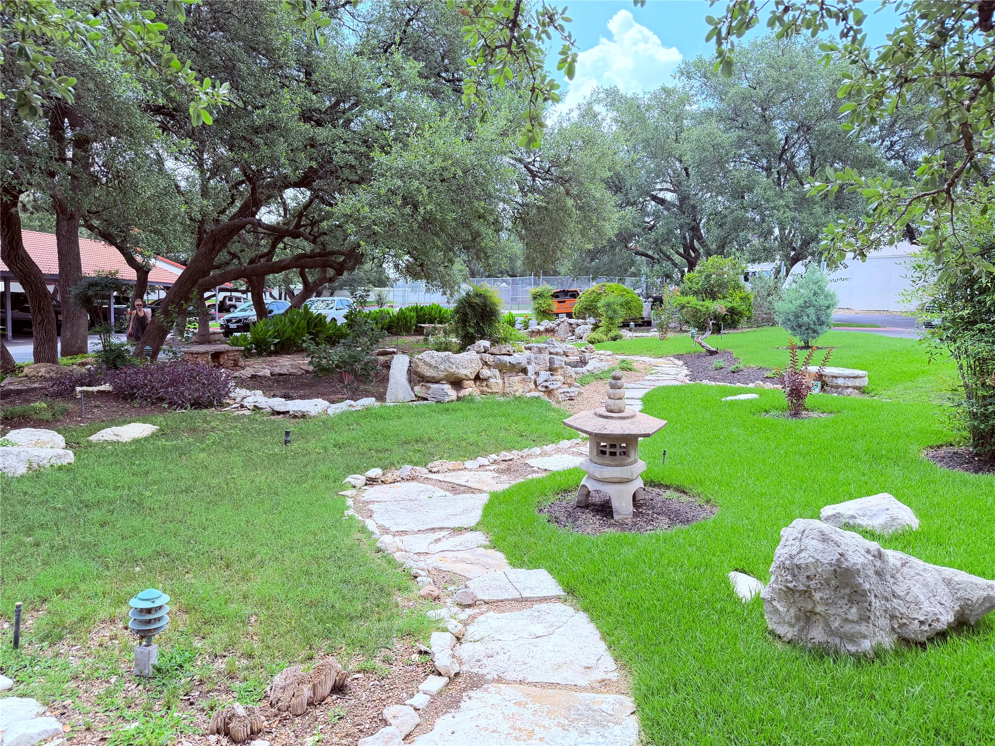 2918 Ranch Road 620 North, Unit C120 Austin, TX 78734 - Photo 3 of 34 An inviting stone pathway meanders through a lush, manicured garden with mature trees , great for relaxing and enjoying the day.