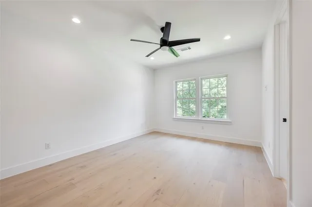 an empty room with a window and a fan