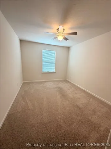 an empty room with a chandelier fan