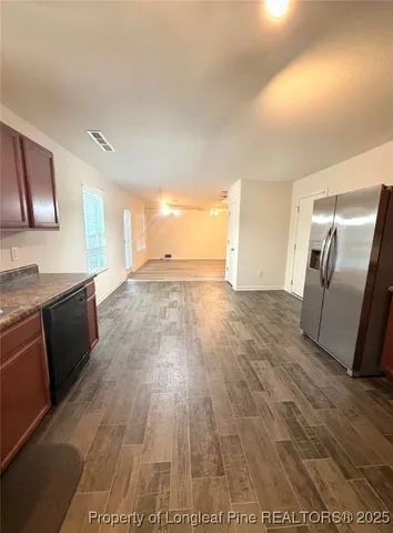 a view of a kitchen with wooden floor and electronic appliances