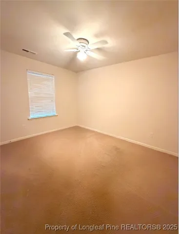 en empty room with windows and fan