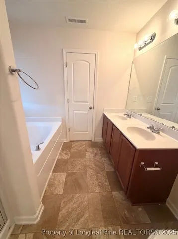 a bathroom with a tub sink and mirror