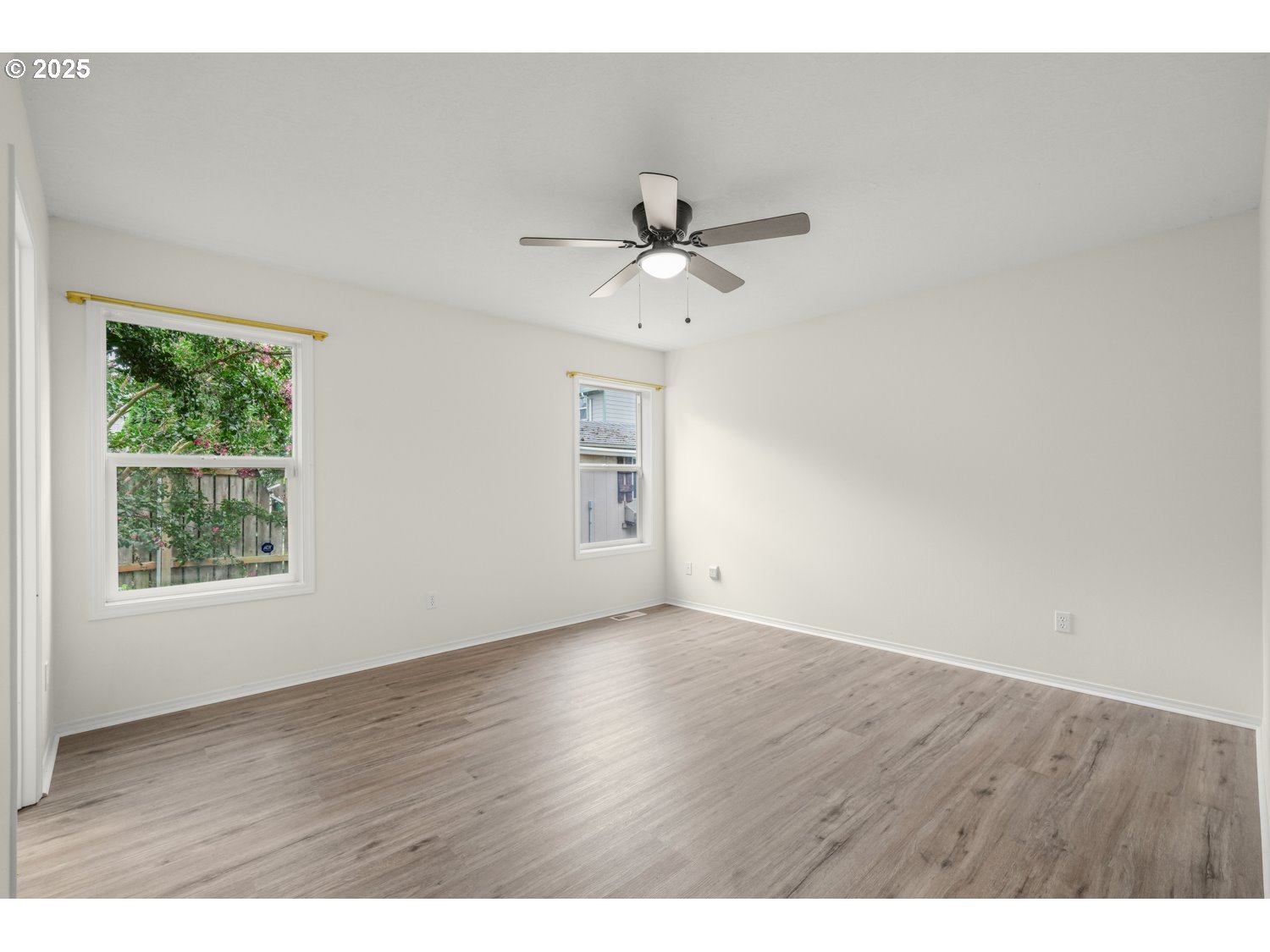 1930 Salmon Run Southwest Albany, OR 97321 - Photo 14 of 26 an empty room with wooden floor chandelier fan and windows