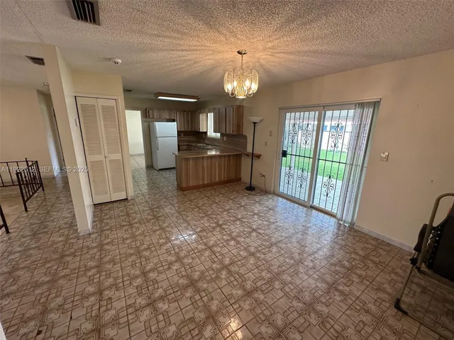 a living room with furniture a flat screen tv and a floor to ceiling window