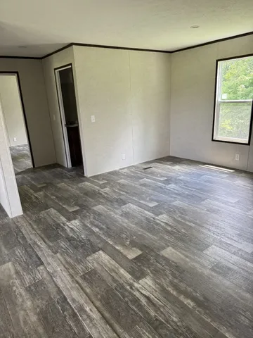 a view of a big room with wooden floor and windows