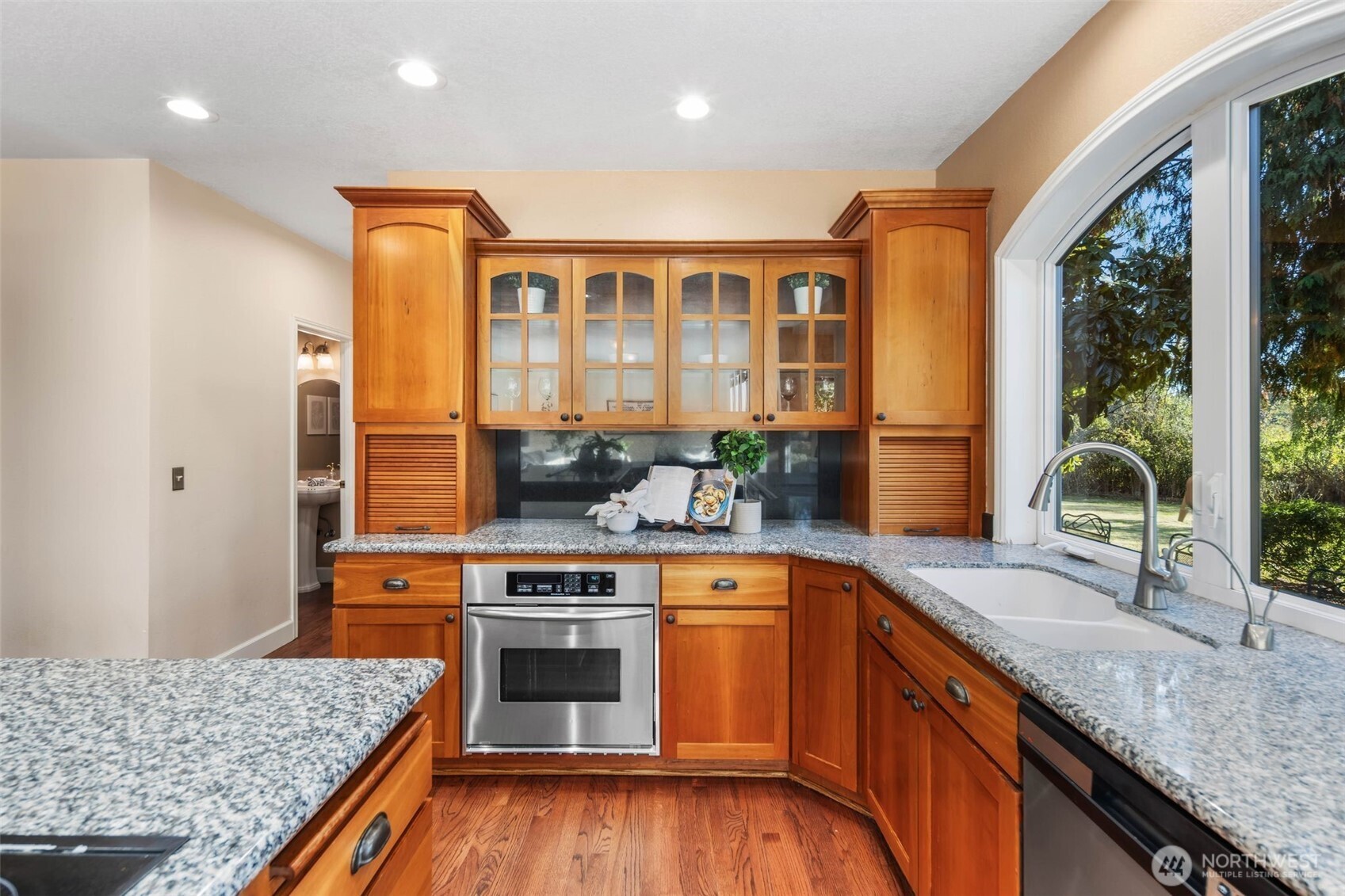 16104 Northeast 6th Court Ridgefield, WA 98642 - Photo 17 of 40 a kitchen with stainless steel appliances granite countertop wooden cabinets and a stove top oven