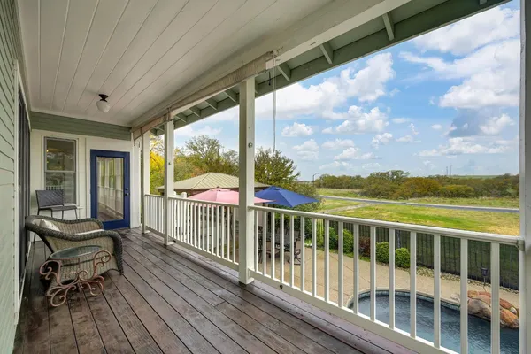 a view of a balcony with wooden floor and iron stairs