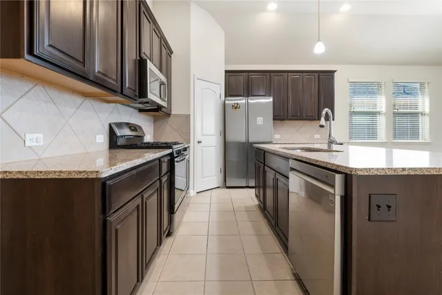 a kitchen with stainless steel appliances granite countertop a sink stove and refrigerator
