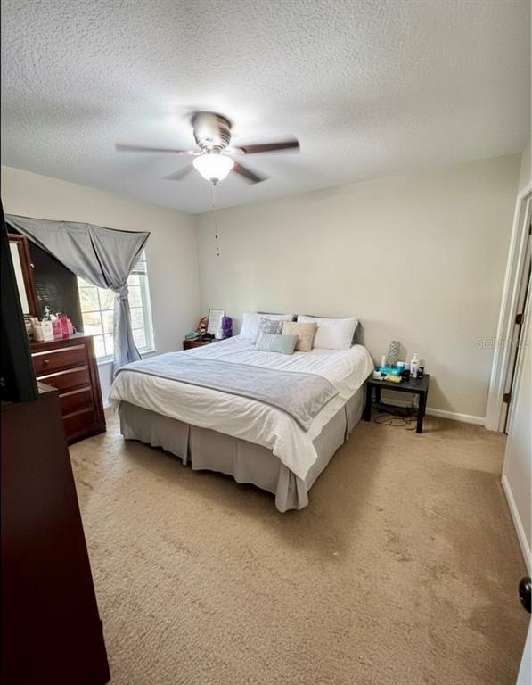 10801 Brickside Court Riverview, FL 33579 - Photo 8 of 16 a bedroom with a bed and a chandelier