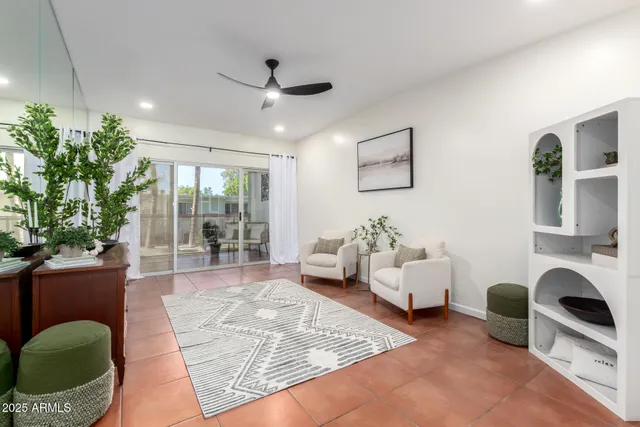 a living room with furniture potted plant and a large window