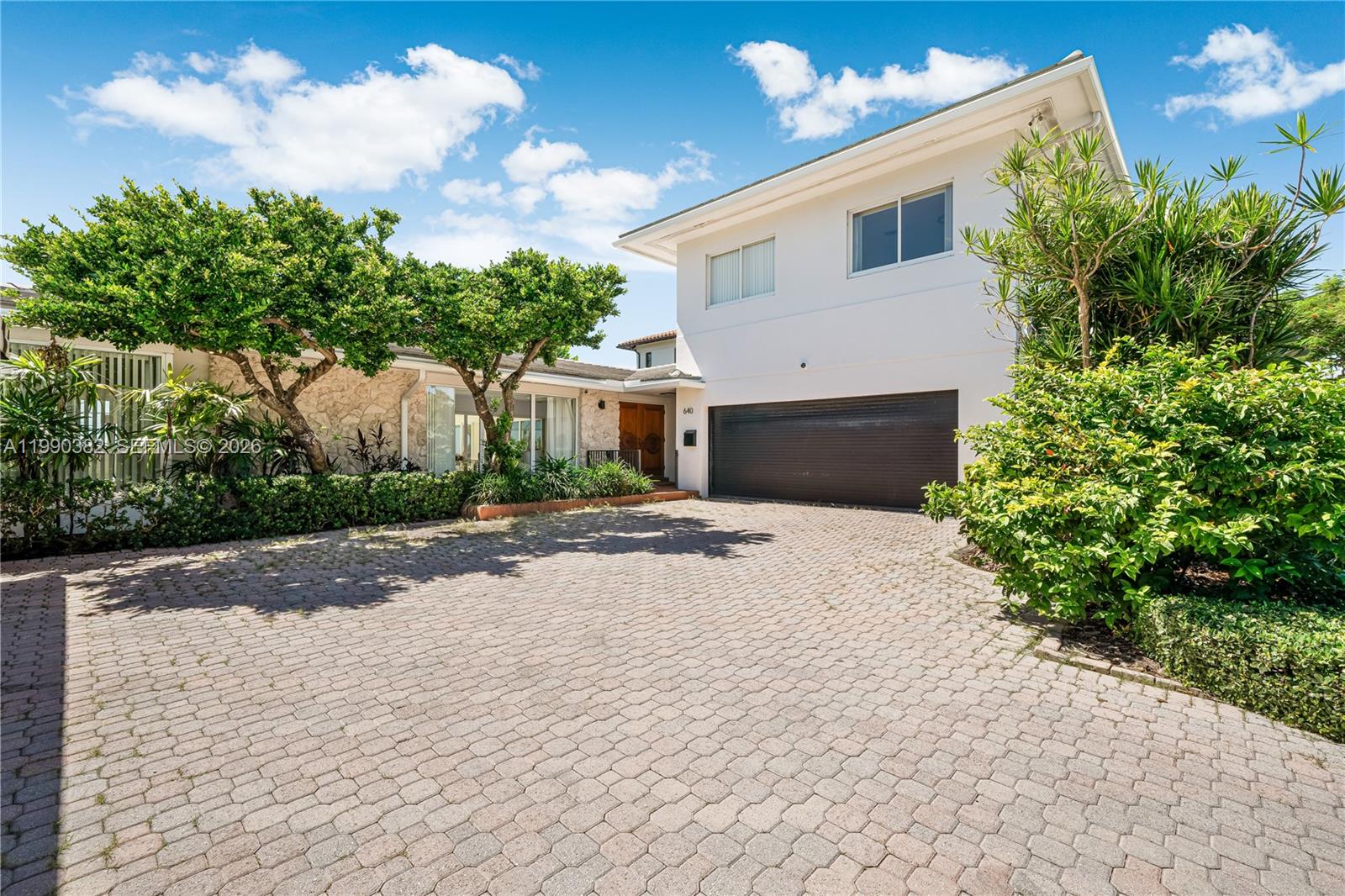 640 South Mashta Drive Key Biscayne, FL 33149 - Photo 4 of 38 a front view of a house with a yard and garage