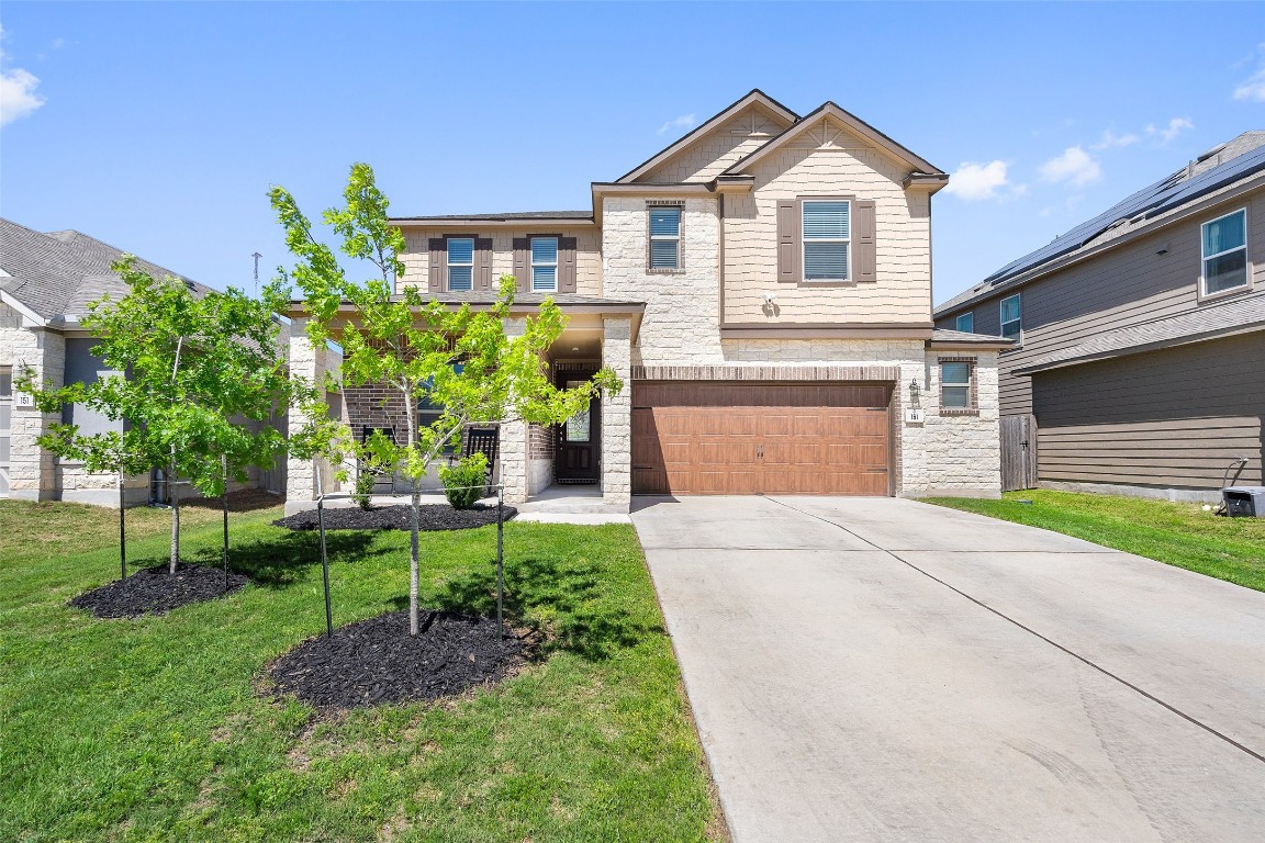 a front view of a house with a yard and garage