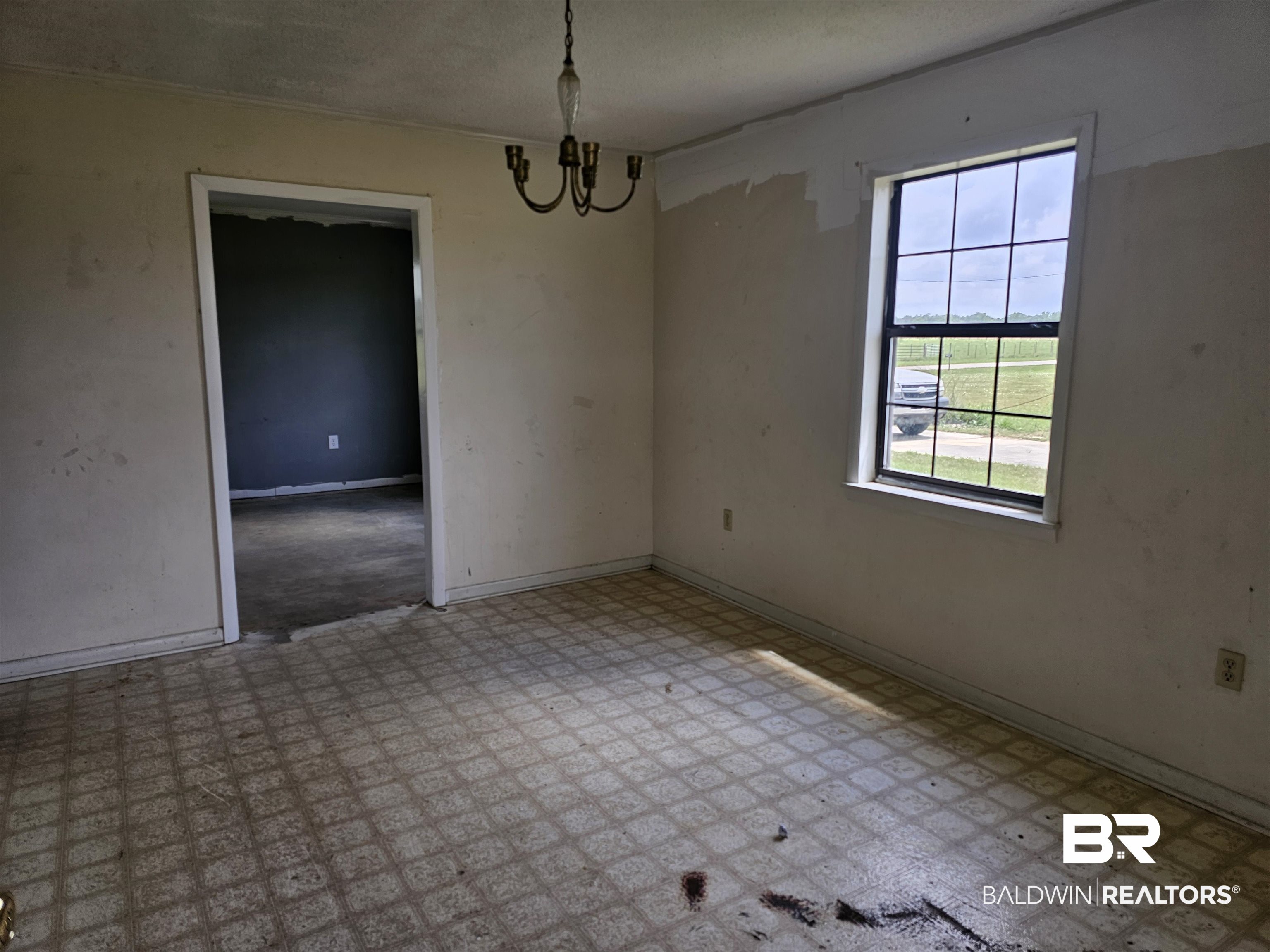 59575 Lottie Road Atmore, AL 36502 - Photo 7 of 23 Unfurnished room featuring a notable chandelier and baseboards