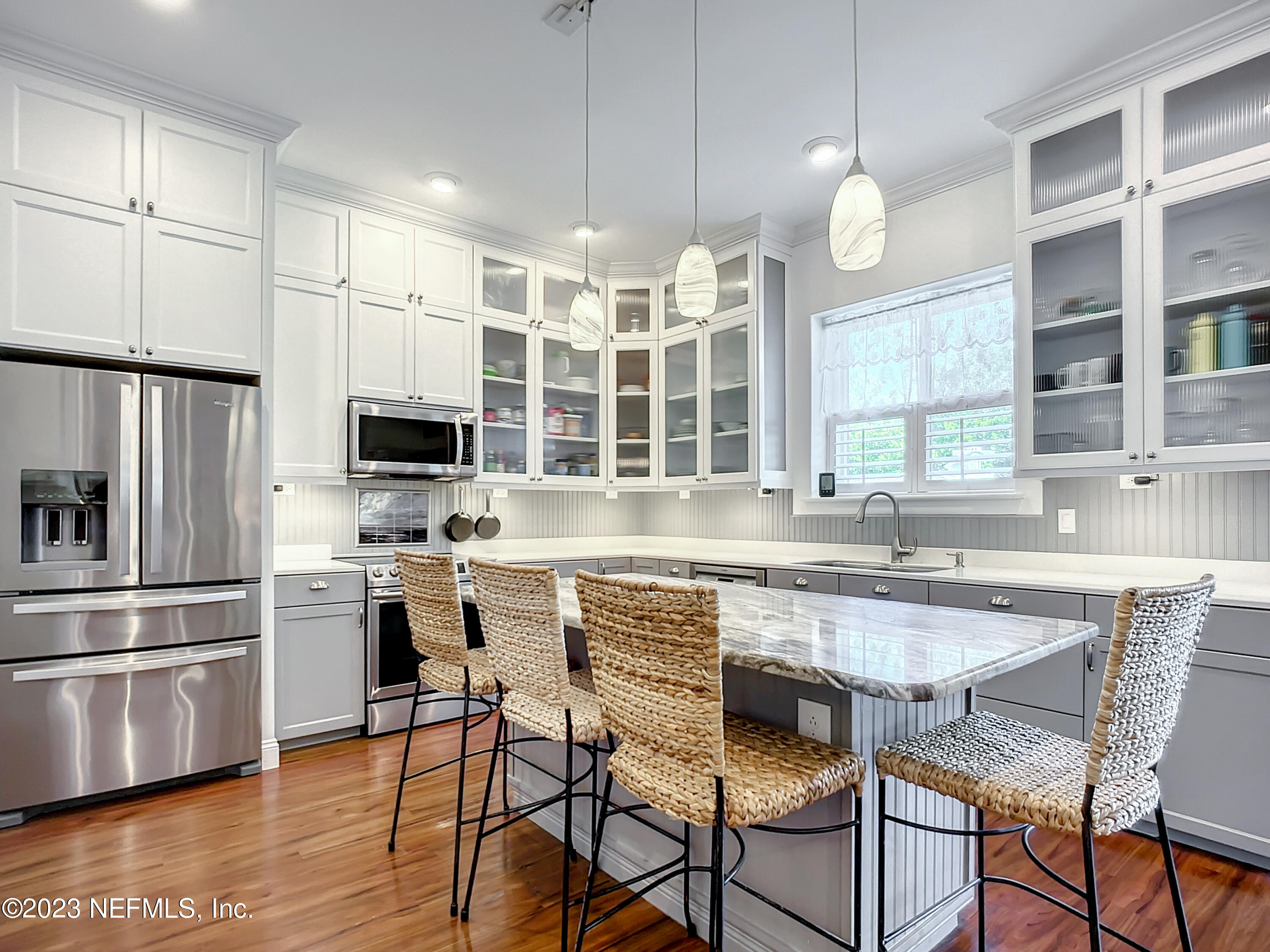 a kitchen with stainless steel appliances a stove a sink a microwave a center island and a refrigerator