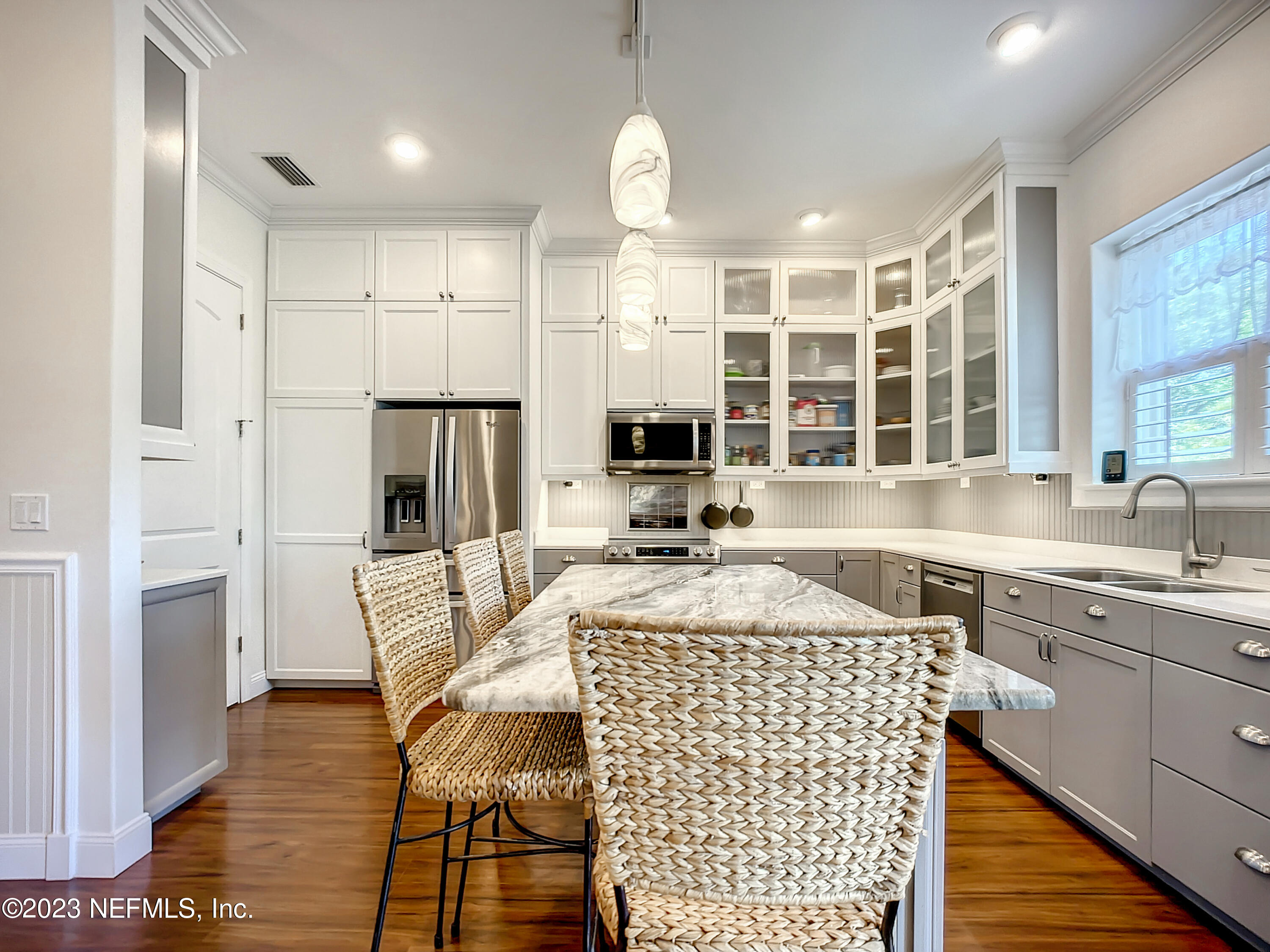 5356 2nd Street St. Augustine, FL 32080 - Photo 15 of 60 a kitchen with stainless steel appliances granite countertop a sink dishwasher a refrigerator and a dining table with wooden floor