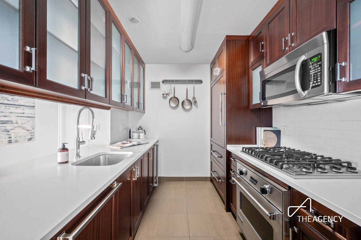 205 West 76th Street, Unit 1202 Manhattan, NY 10023 - Photo 3 of 11 a kitchen with stainless steel appliances a stove a sink and a microwave