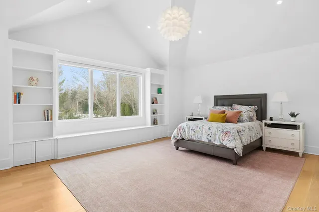 a bed sitting in a spacious bedroom next to a window