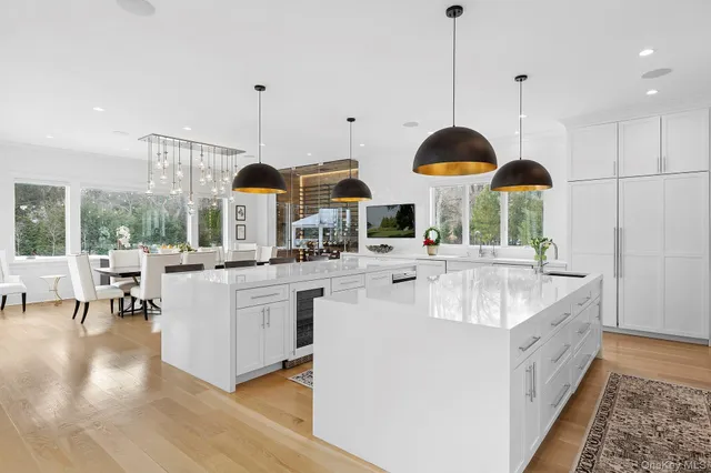 a large kitchen with kitchen island granite countertop a sink a counter and chairs