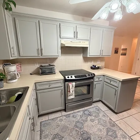 a kitchen with stainless steel appliances granite countertop a sink stove and cabinets