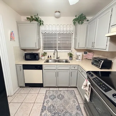 a kitchen with a sink a stove and cabinets