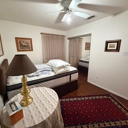 a bedroom with a bed and a lamp on dresser