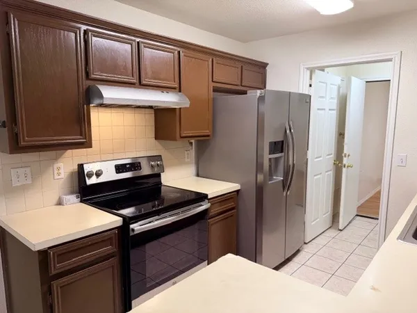 a kitchen with a refrigerator stove and cabinets
